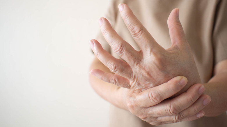 Person gripping wrist with other hand