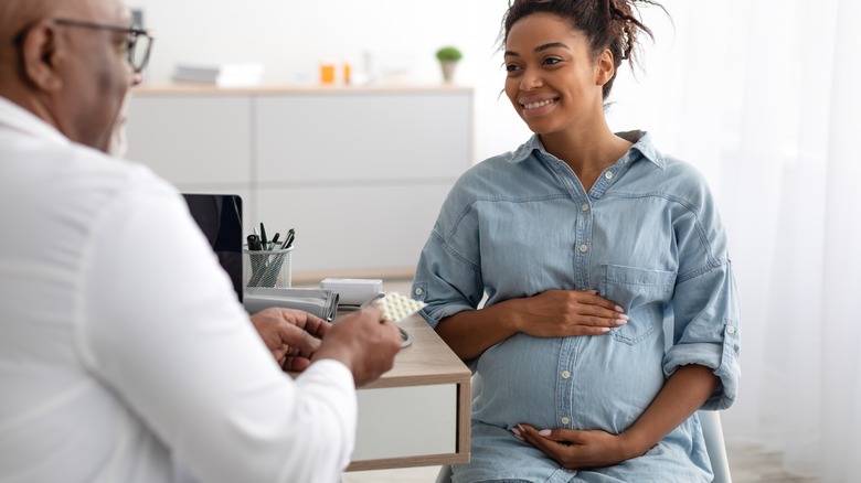 Pregnant woman with doctor in office