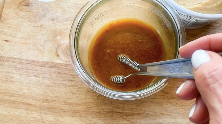 sauce in small bowl being whisked