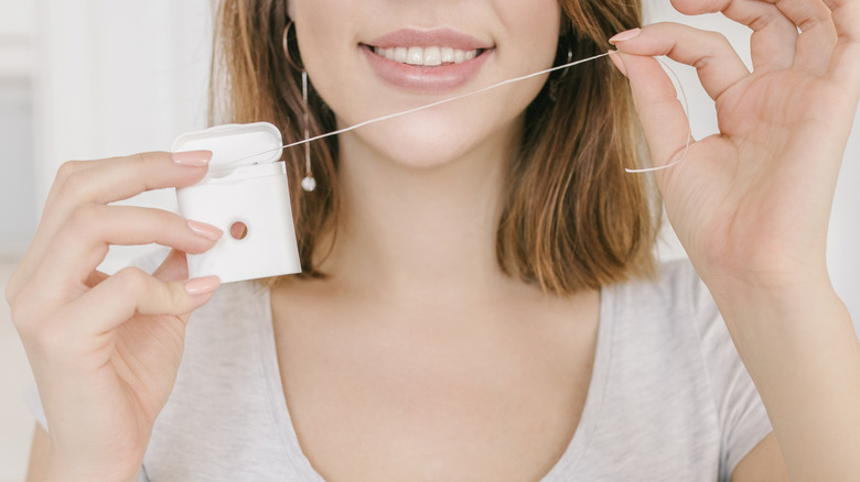 woman holding dental floss