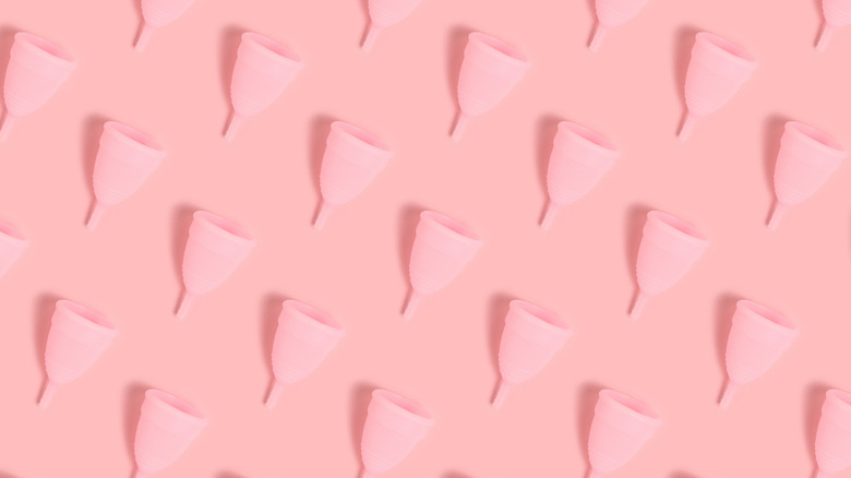 menstrual cups laid over a pink background