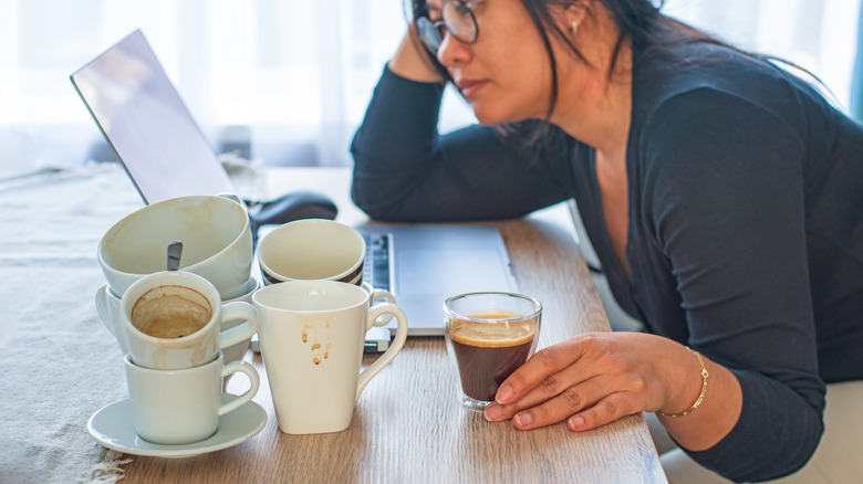 woman with empty coffee cups