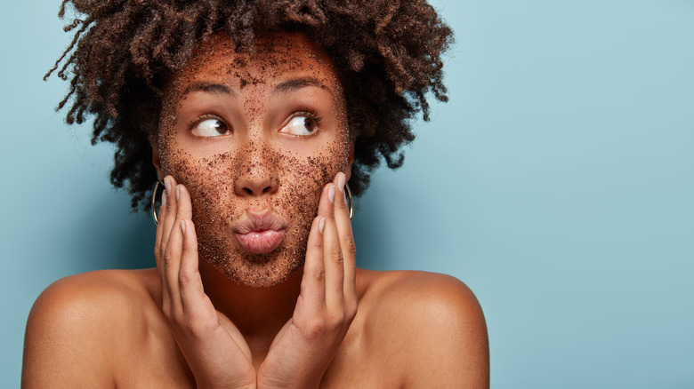 woman using exfoliating cleanser on face