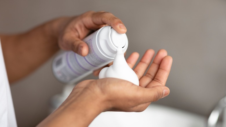 Hands pouring shaving cream