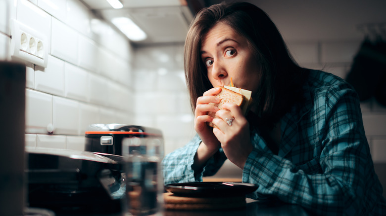 woman eating a sandwich at night