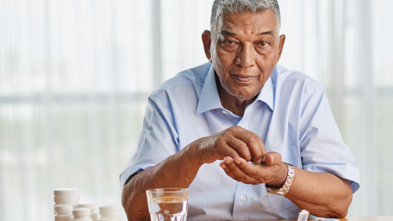 man holding medications in hand