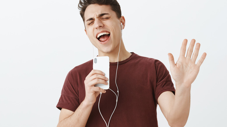 man singing with earbuds in