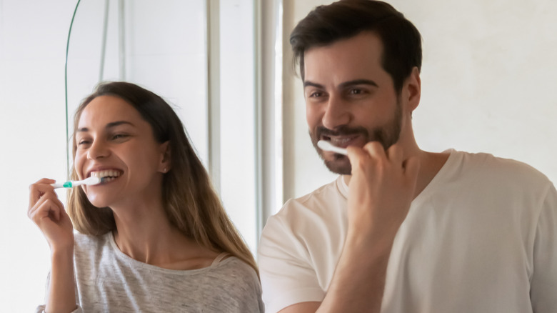 couple brushing their teeth together