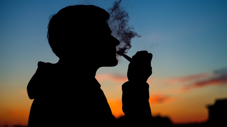man smoking pipe outdoors silhouette