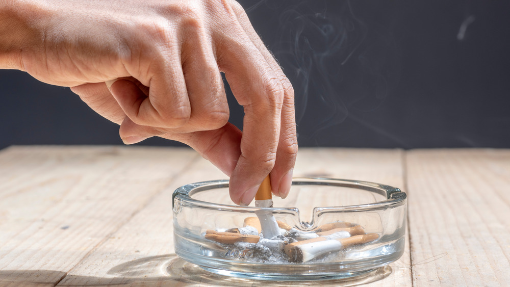 putting out cigarette in ash tray