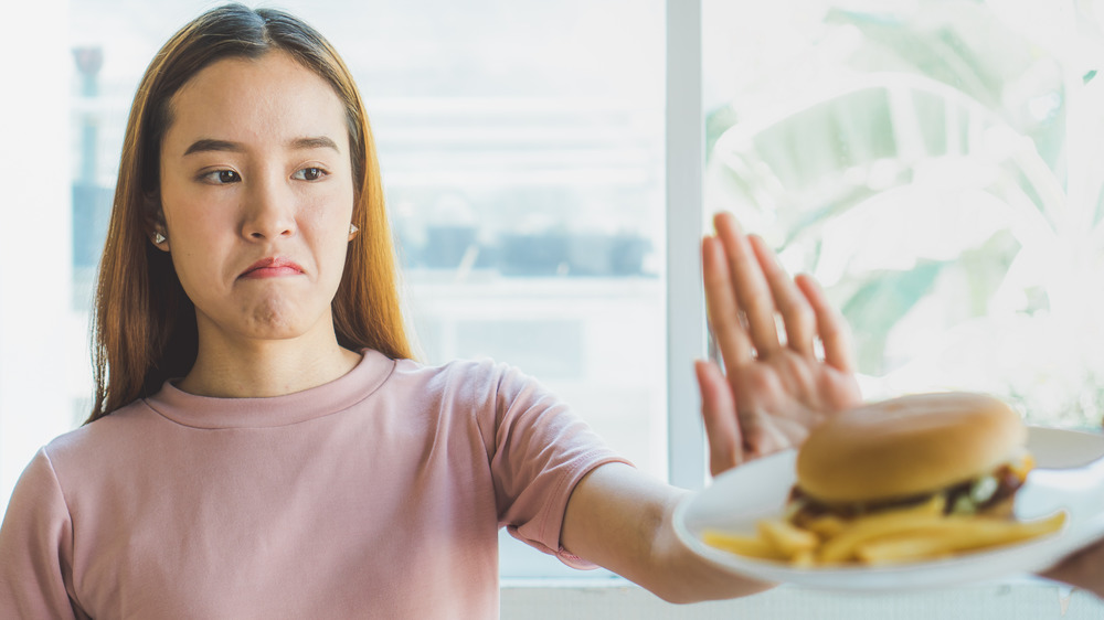 woman refusing hamburger