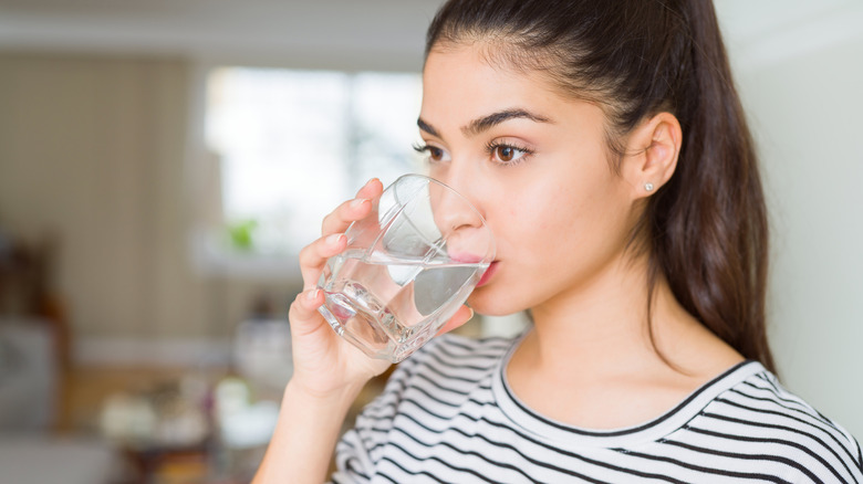 Woman drinks a glass of water