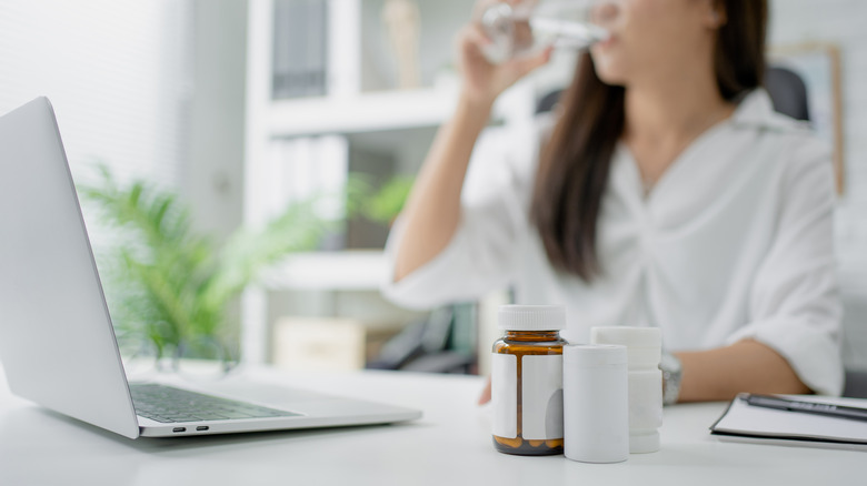 pill bottles and woman drinking