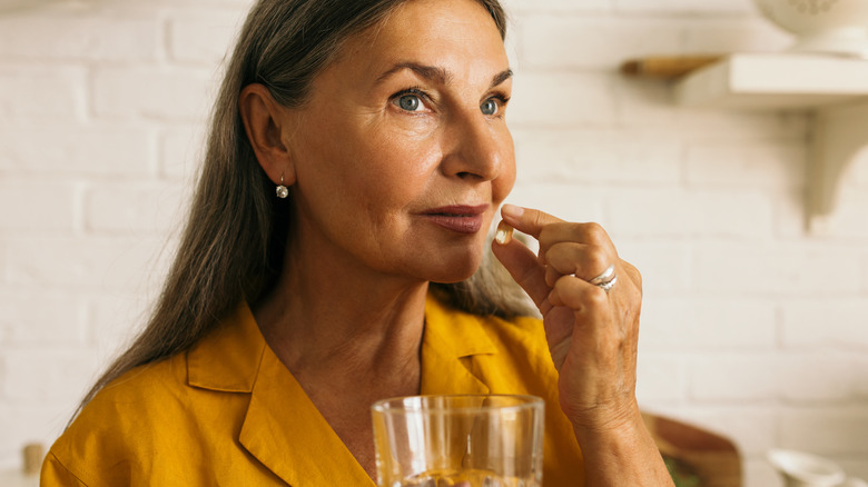 woman taking pill with water
