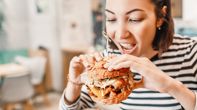 a hungry woman about to eat a large burger