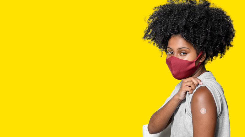 a woman shows her booster bandaid