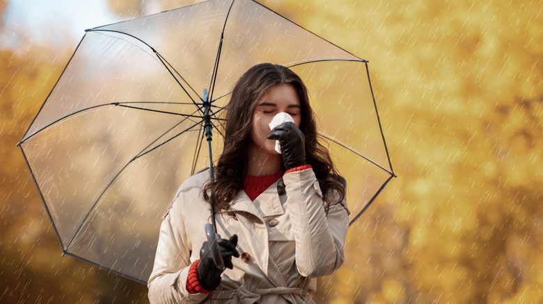 woman sneezing in the rain