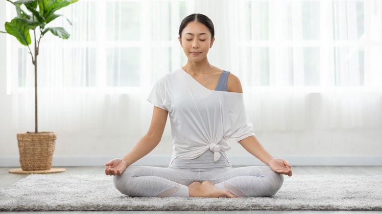 woman meditating in white room