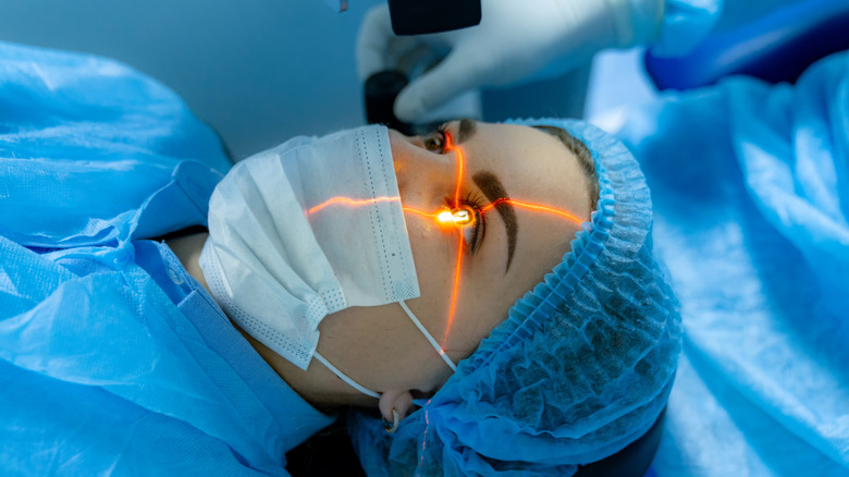 laser over woman's eye during eye surgery