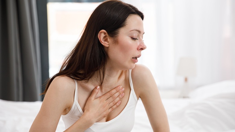 woman coughing and holding neck