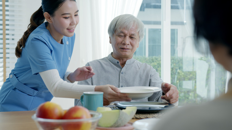 woman serving older man food