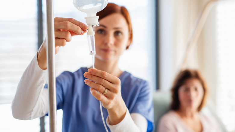 a nurse preparing an IV drip for a female patient