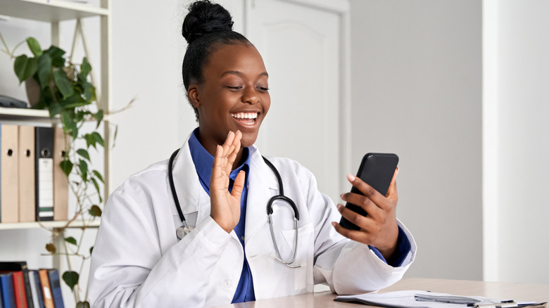 doctor holding phone for telemedicine visit