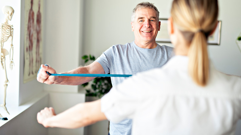 physical therapist and patient with resistance bands