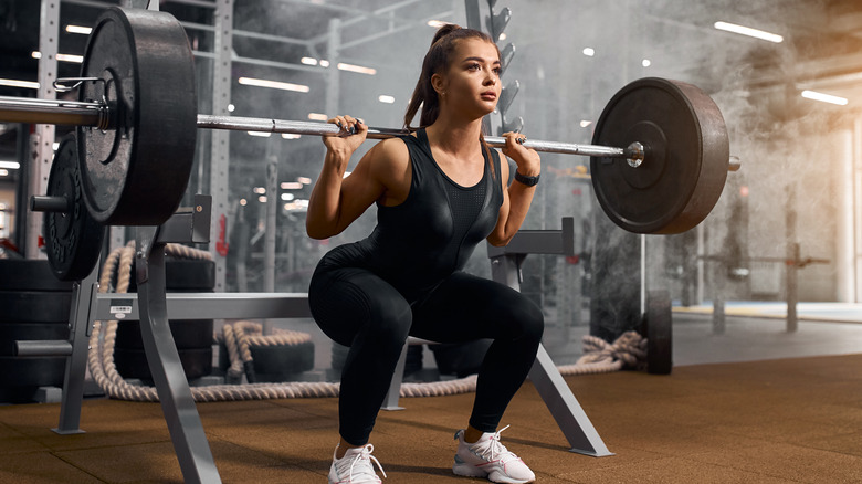 strong woman doing barbell squat