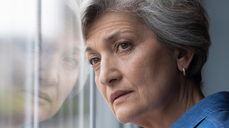 Lonely woman looking out window