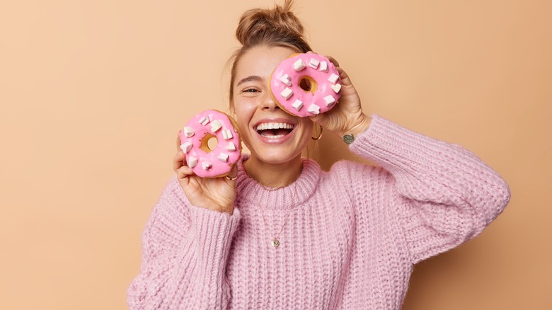 happy woman holding two donuts