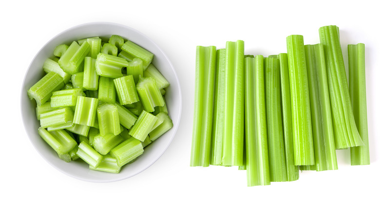 bowl of chopped celery next to celery stalks