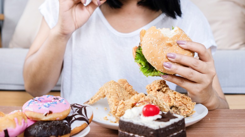 person eating variety of unhealthy foods