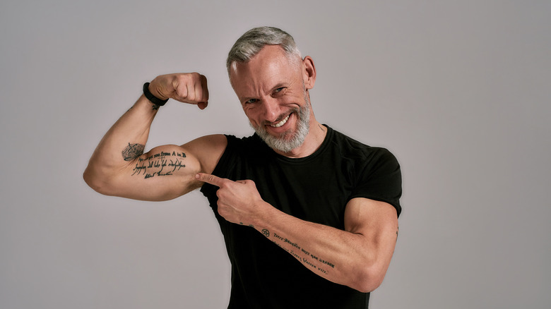 Smiling man points to tattoo