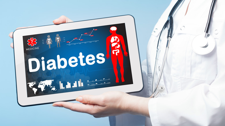 Doctor holding an electronic tablet displaying information about diabetes
