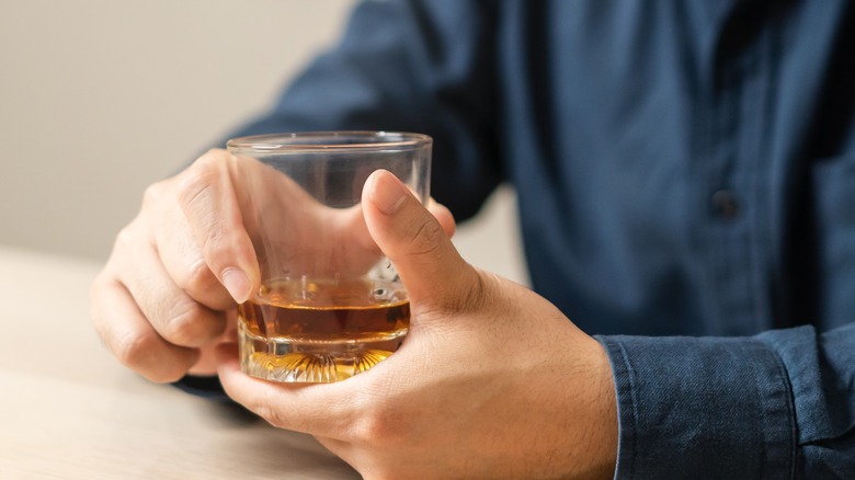 man holding glass of alcohol