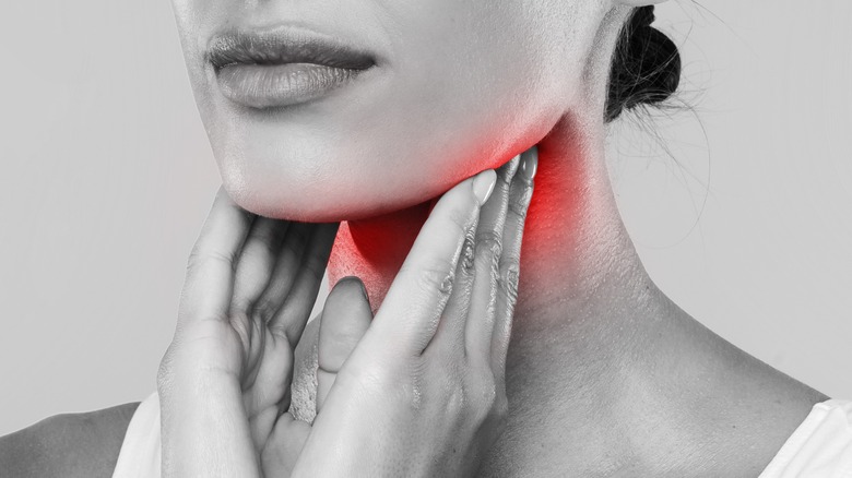 woman touching red tonsils 