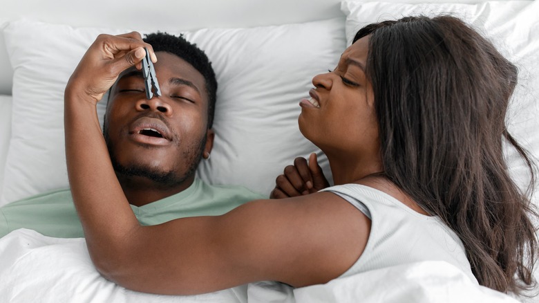 man snoring with frustrated partner