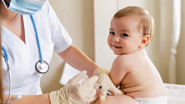 Nurse preparing to give baby vaccination