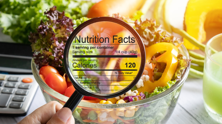 food label showing nutrition facts with salad in background