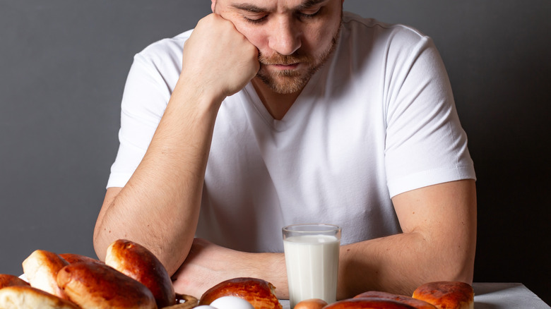 man contemplating eating bread and milk