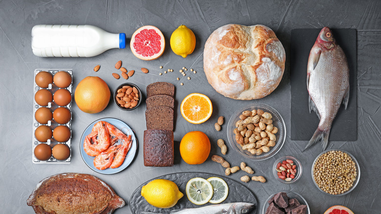 eggs, fish, bread, peanut, milk, lemon and orange on counter