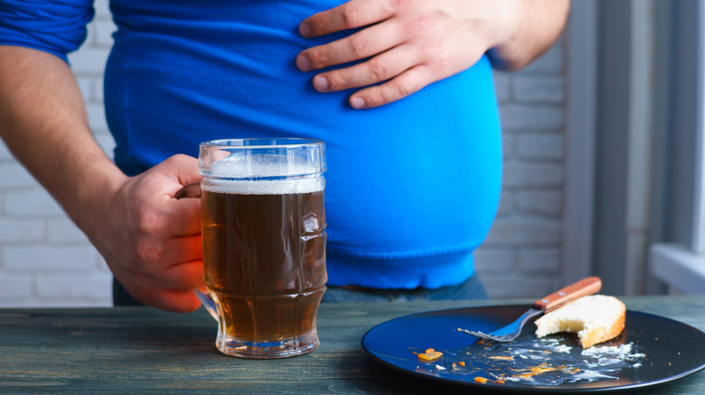 Fat man holding beer