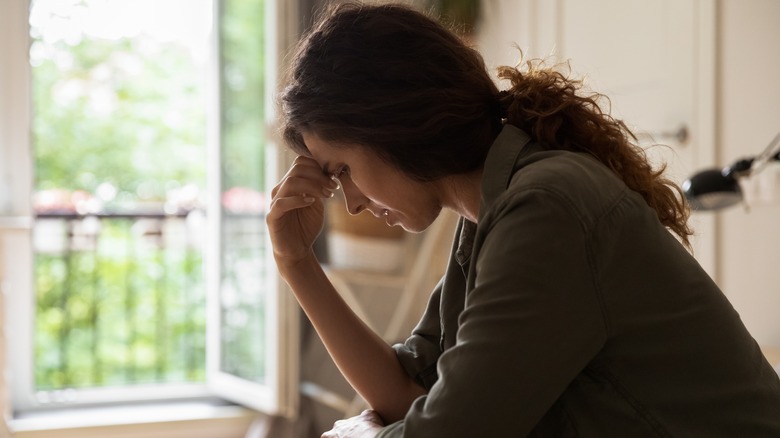 depressed woman with hand on forehead