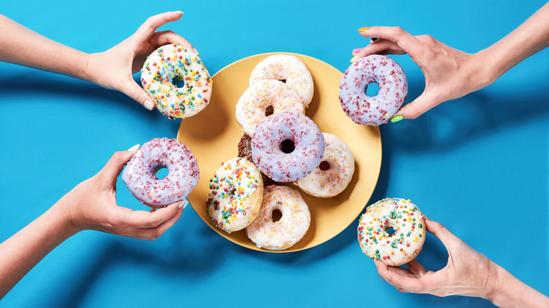 hands reaching in for doughnuts