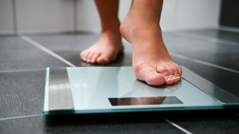 female feet stepping on a scale