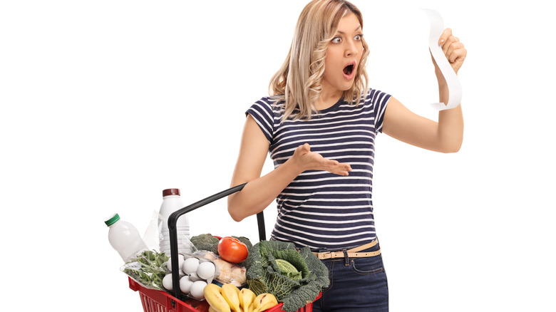 Young woman shocked by grocery bill