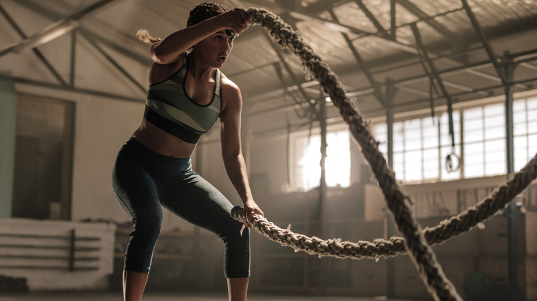 Woman training with battle ropes 