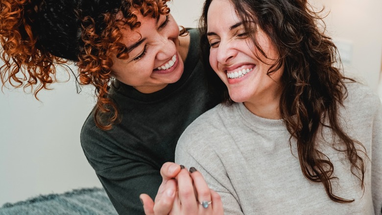 A couple laughing and holding hands