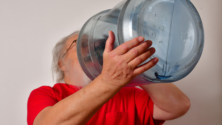 older man drinking 5-gal water